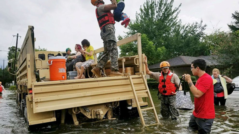 First responders help residents evacuate from a neighborhood flooded by a hurricane. Photo by EPA.